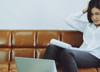The unintended consequences of the e-wallet ban in the Philippines Businesswomen looks at her laptop with her hands on her head in dismay