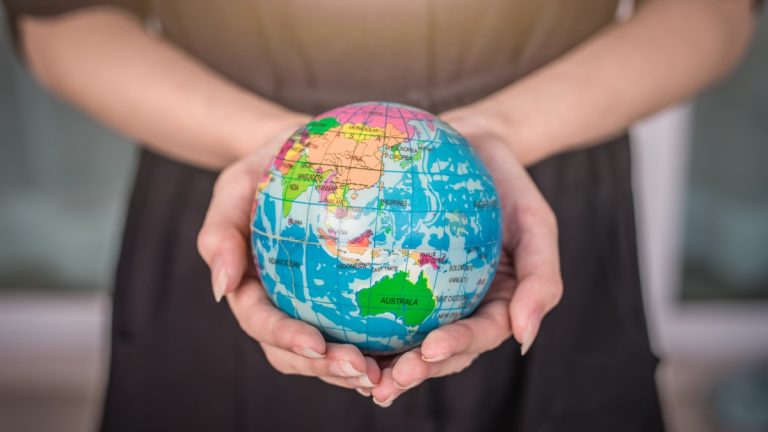Womans hands hold a globe