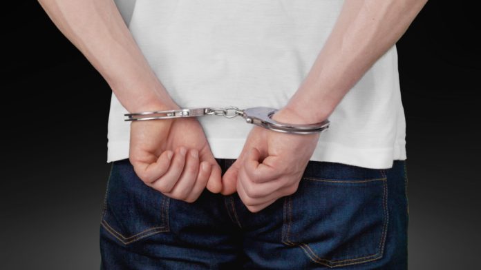 macau-crackdown-illegal-money-exchanges Close up of man in handcuffs behind back