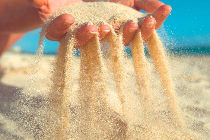 Sand slipping through fingers