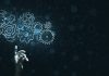 Beyond the buzzword: Vegangster on AI’s Role in the Future of iGaming A hand touches virtual gears, representing Vegangster using AI.