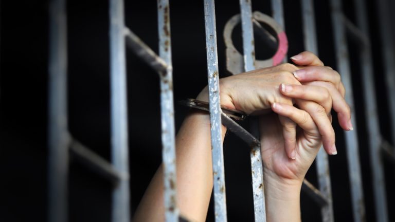 Alice Guo given life sentence for POGO-related human trafficking A womans hands cling on to the railings of a prison cell