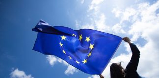 EU ruling delivers Malta fresh setback against foreign challenges of iGaming licences Woman holds EU flag