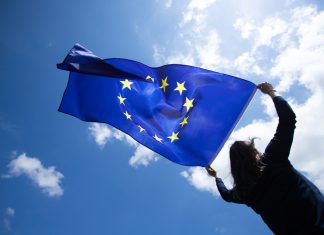 EU ruling delivers Malta fresh setback against foreign challenges of iGaming licences Woman holds EU flag