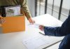 Consequences continue for Flutter in India Person handed notice carrying box of belongings