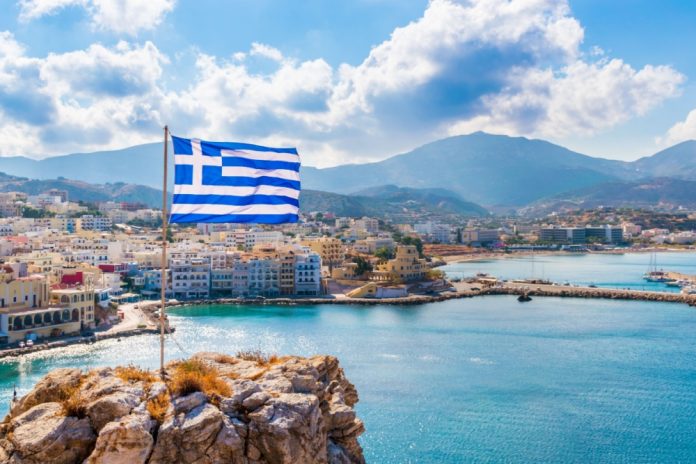 Greece flag looks over a bay