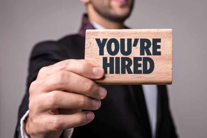 Businessman holds you're hired sign