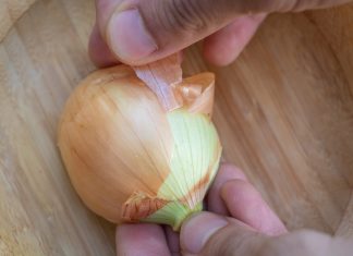 Vegangster removes ‘final layer of friction’ with latest feature Close up a hand peeling an onion