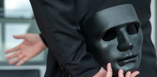 How false licensing claims continue to plague key gambling regulators Businessman holds mask behind his back