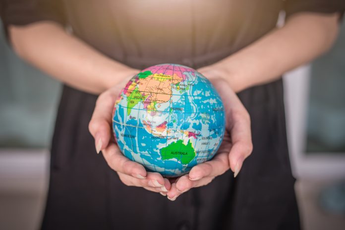 Swintt x SkillOnNet Woman holding globe
