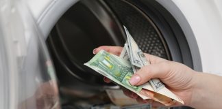 The Philippines eyes strengthened AML enforcement against online gambling Close up of hand putting money into a washing machine