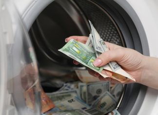 The Philippines eyes strengthened AML enforcement against online gambling Close up of hand putting money into a washing machine
