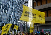 Amnesty International demands investigation into casino abuse in Cambodia Amnesty International flag at a protest
