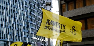 Amnesty International demands investigation into casino abuse in Cambodia Amnesty International flag at a protest