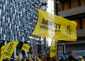 Amnesty International demands investigation into casino abuse in Cambodia Amnesty International flag at a protest