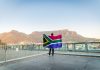 Yggdrasil steps up South Africa presence with a duo of partnerships Man holding up South Africa flag