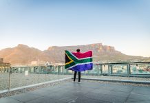 Yggdrasil steps up South Africa presence with a duo of partnerships Man holding up South Africa flag
