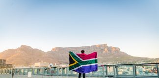 Yggdrasil steps up South Africa presence with a duo of partnerships Man holding up South Africa flag