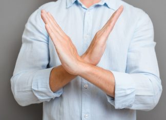 Sportradar rallies back against claims of targeting illegal Asian markets Close up of a man crossing their arms in an x