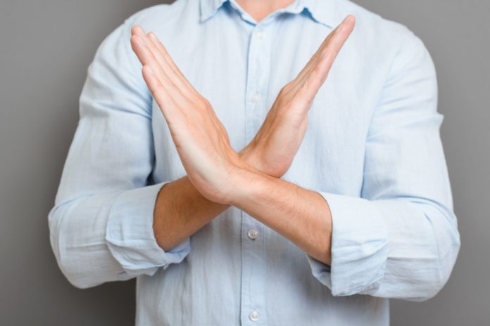 Close up of a man crossing their arms in an x
