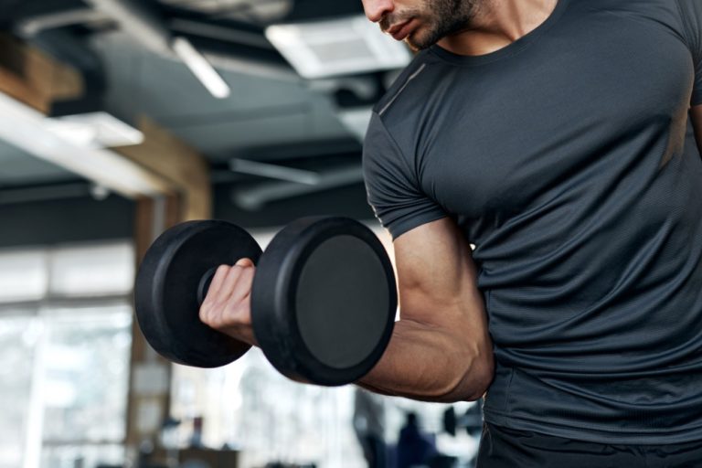 Man curls dumbbell