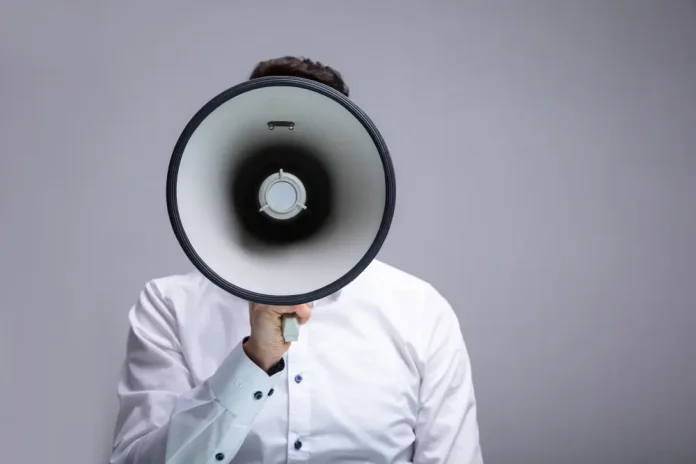 Close up of a man shouting through a megaphone