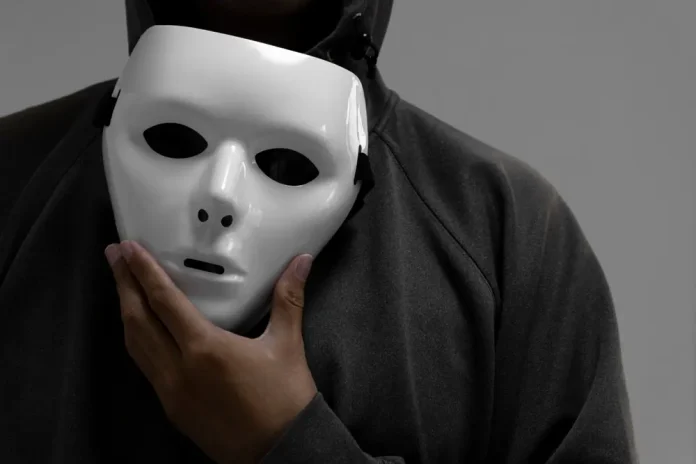 Man holdimg white mask