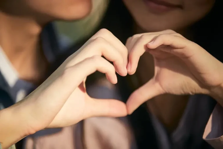Couple making love heart with hands