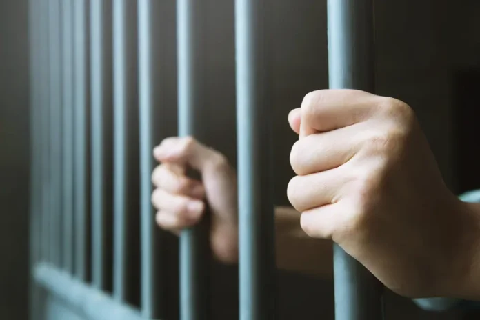 Thai illegal gambling conviction Man holds on to railing of a jail cell