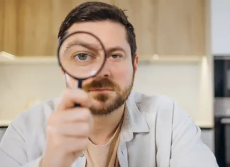 Report calls for UK regulator investigation over black market inaction Man looks through magnifying glass